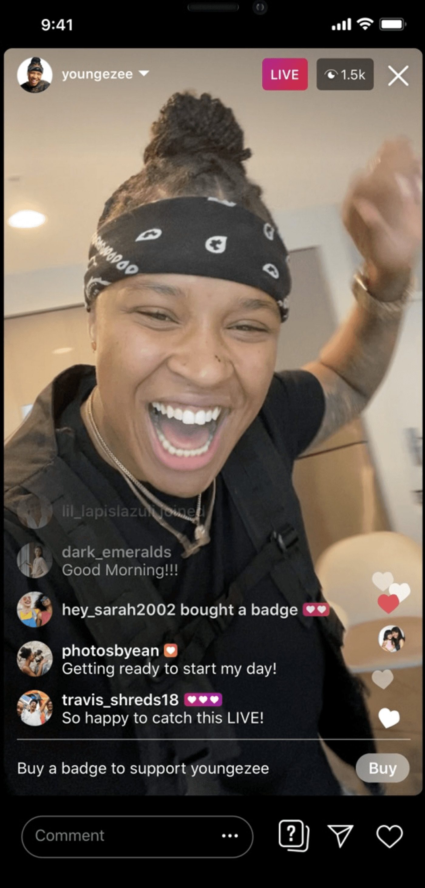 Young woman hosting a live video, smiling with comments and badges from viewers.
