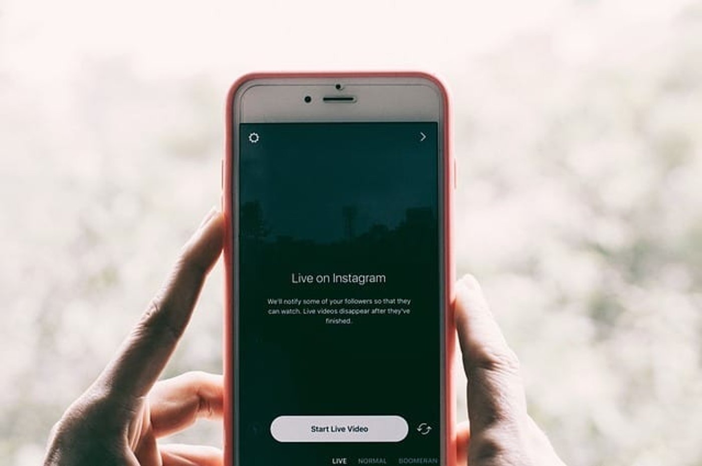Manos sosteniendo un móvil apuntando al paisaje y listo para hacer una live abierta en instagram