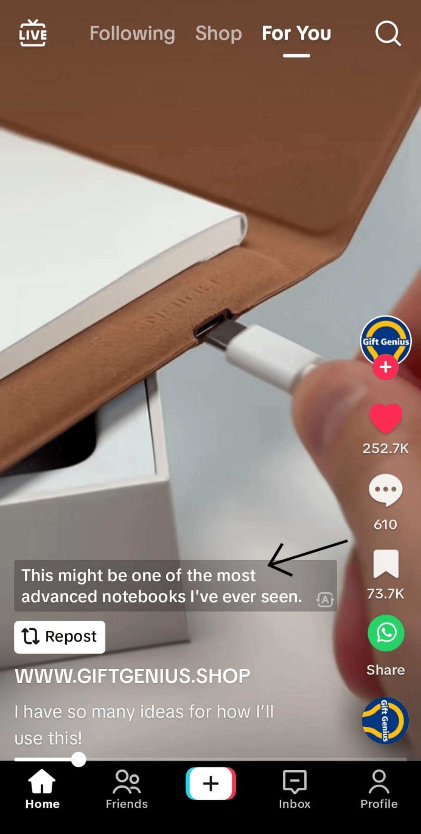 Close-up of a hand plugging a device into a notebook, labelled as advanced tech of Gift Genius Shop.