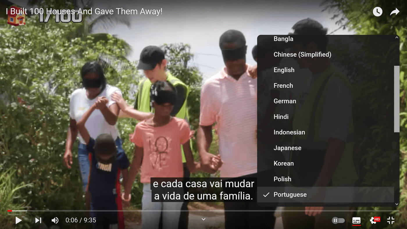 People holding hands blindfolded with subtitles in Portuguese saying every house changes lives.