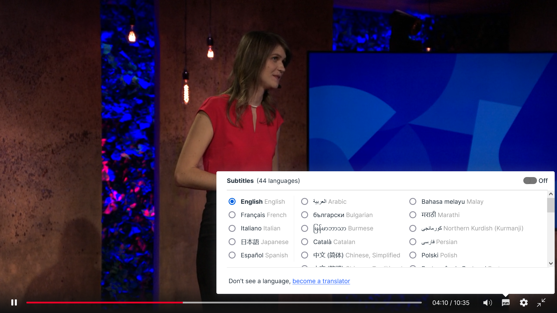 Female speaker in red top presenting a TED Talk with subtitle language options shown in English and 43 others.